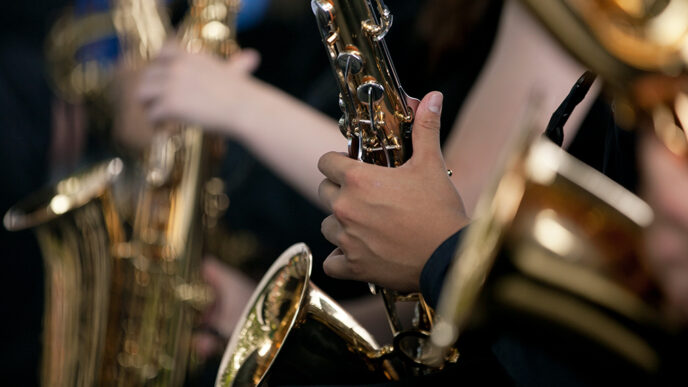 Detail of students' hands playing saxophones.
