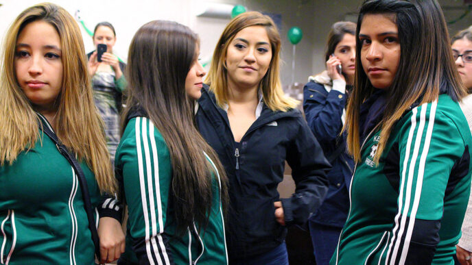 Girls from the Kelly High School soccer team discuss the film after a screening in the school auditorium||In a hallway at Kelly High School.