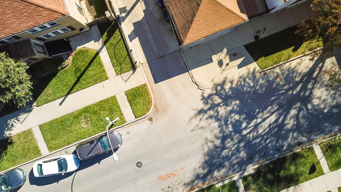 Aerial view of a residential street with cars parked along a curb