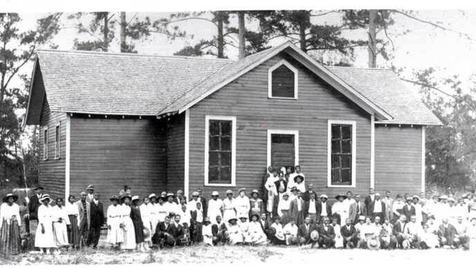Historic photo of town residents posing in front of newly built Rosenwald School in Alabama