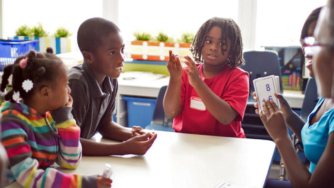 Students at Breakthrough Youth Network use flash cards to practice math problems|A teacher talks with a class of young girls|Two students share a hug in the courtyard at Breakthrough Youth Network.