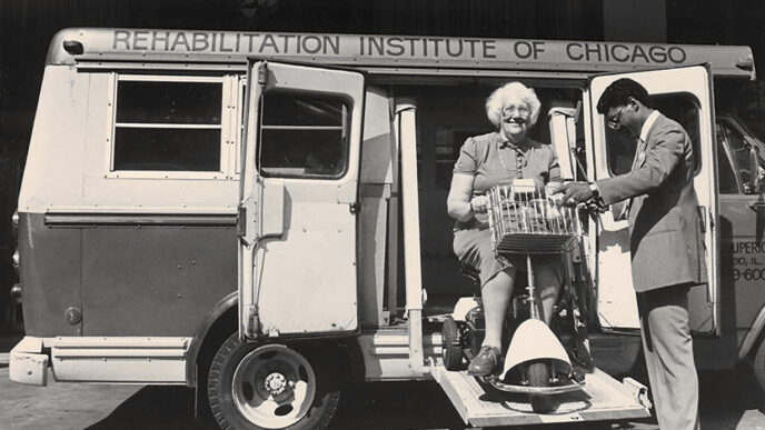 Archival photo shows women using mobility scooter entering a Rehabilitation Institute of Chicago van|