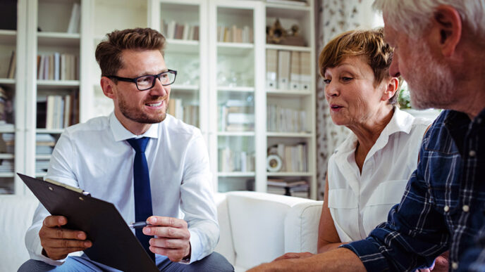 A financial advisor sits beside an older couple.