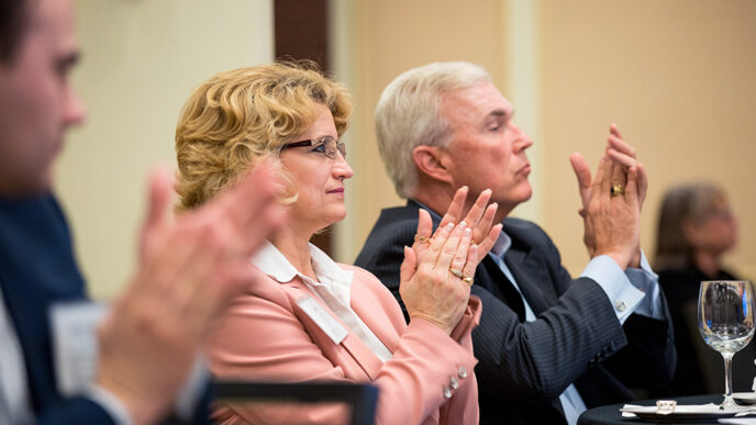 A group of people seated in a meeting room.