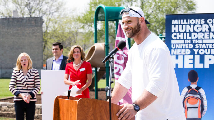 Kyle Long at the podium announcing support for Blessings in a Backpack|.