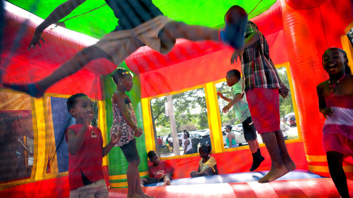 Children play inside a bouncy castle at Rainbow Beach Park during National Night Out|Friends Geraldine and Fallen at Rainbow Beach Park during National Night Out|CAPS volunteer Angela with her father Floyd at Rainbow Beach Park during National Night Out|South Shore resident Jackie shares a park bench with two neighbors at Rainbow Beach Park during National Night Out|Photographer Laura of the website Work Together for Peace at Rainbow Beach Park during National Night Out|Seventh Ward Alderman Greg Mitchell at Rainbow Beach Park during National Night Out|Arnetta watches the crowd at Rainbow Beach Park during National Night Out|Amos watches his granddaughters play at Rainbow Beach Park during National Night Out|Angelshares a snack with her two nieces at Rainbow Beach Park during National Night Out|Sally sports a vibrant purple straw hat at Rainbow Beach Park during National Night Out|Rev. Gregory Rom of St. Felicitas Catholic Church talks with a police officer at Rainbow Beach Park during National Night Out|Volunteer Sonya passes out snacks at Rainbow Beach Park during National Night Out.