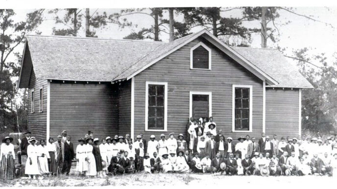 Historic photo of town residents posing in front of newly built Rosenwald School in Alabama.