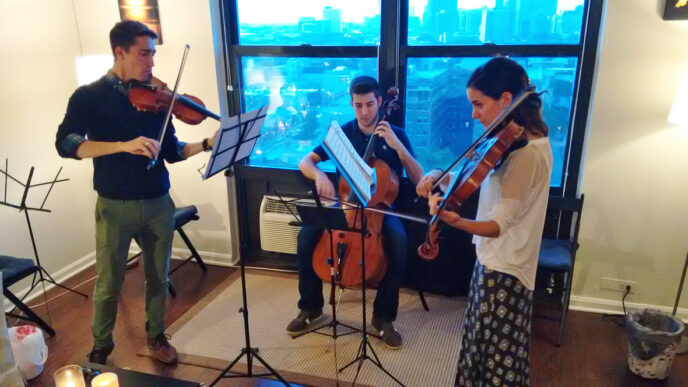 Three string musicians from GroupMuse tune up in a Chicago apartment.