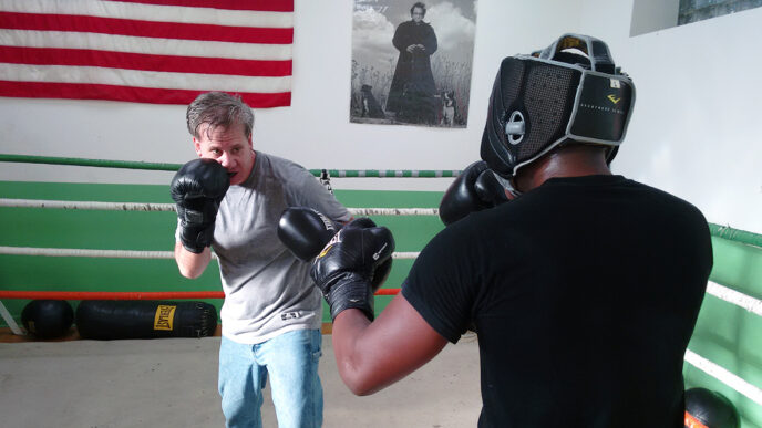 Celtic Boxing Club founder Mike Joyce and trainee Gregory George in the ring|A local fighter trains in the gym at Celtic Boxing Club.