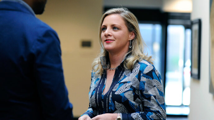 Randi Belisomo listens during a conversation in a hallway||.