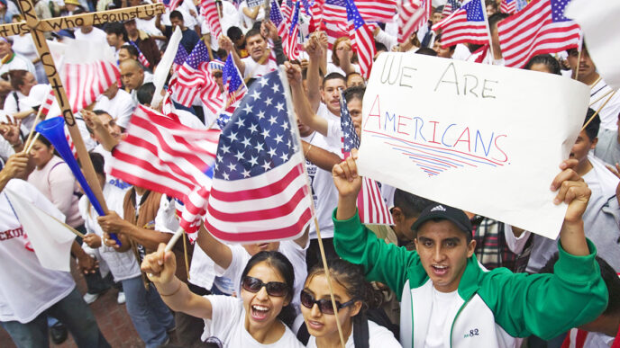 Latinos hold American flags and signs at a rally|Latinos hold American flags and signs at a rally|.