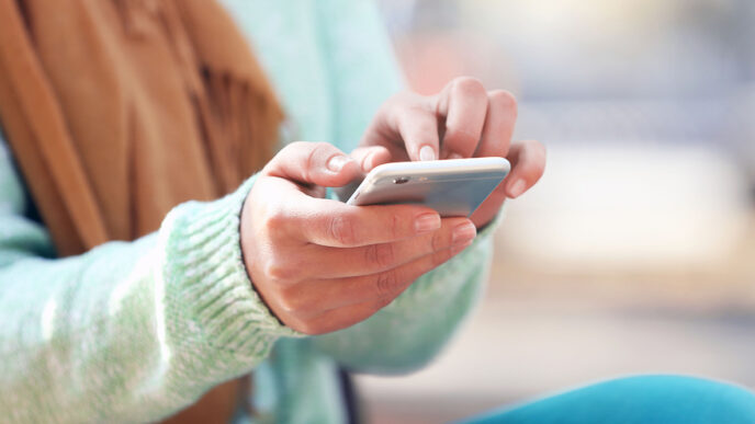 Hands holding a phone and texting|Nancy Lublin riding a bicycle.