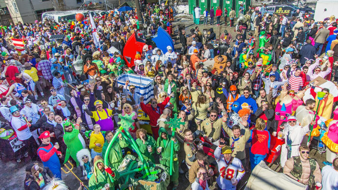 A large crowd in colorful costumes gathers at the starting line of the Chiditarod charity race|.