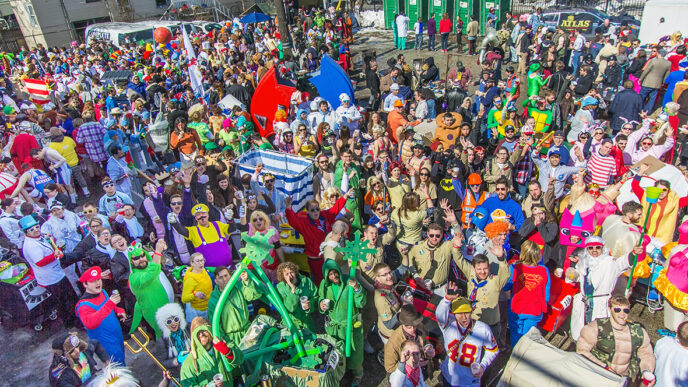 A large crowd in colorful costumes gathers at the starting line of the Chiditarod charity race|.