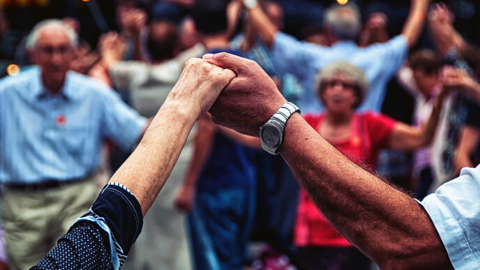 Two people holding hands in a group of dancers.