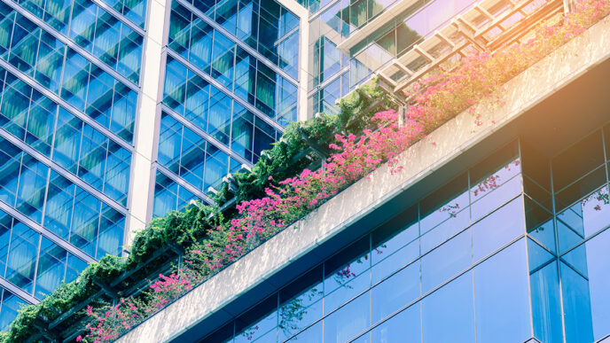 Exterior of 'green' building with planters built into walls|Members of the GenG collaboratory on stage during “pitch day” in March 2015|Dhruti Patel.