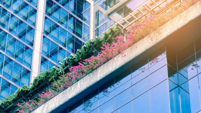 Exterior of 'green' building with planters built into walls|Members of the GenG collaboratory on stage during “pitch day” in March 2015|Dhruti Patel