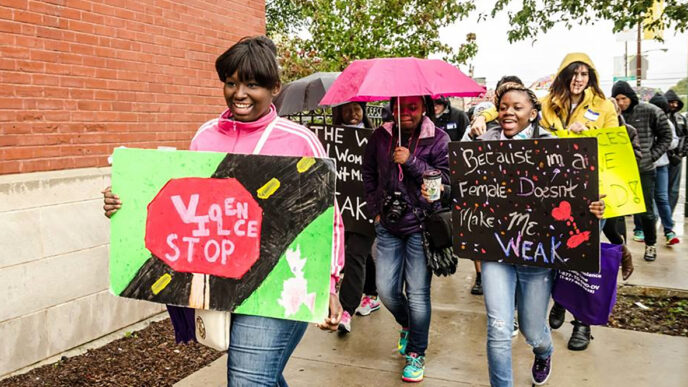 Marchers carry signs in a walk to protest violence against women.