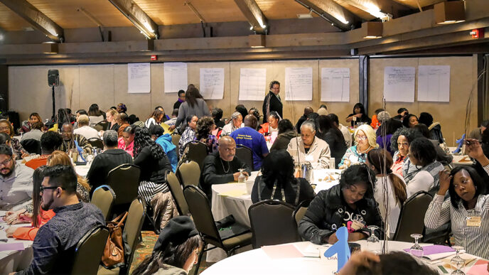 A room full of parents during a family engagement workshop at Youth Guidance|A parenting skills teacher talks to group of adults in a classroom at Chicago Youth Centers|.