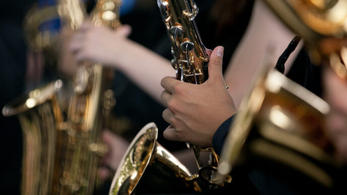 Detail of students' hands playing saxophones.