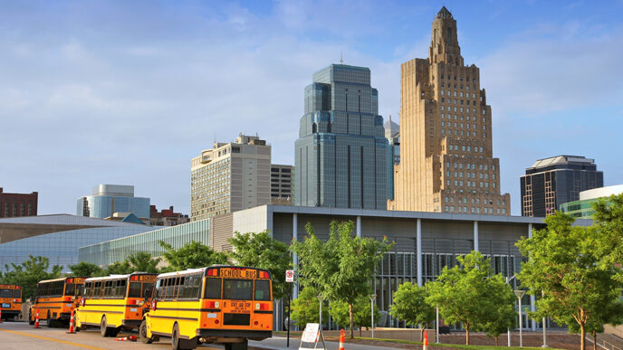 Buses outside a school in Kansas City with the skyline in the background|Kansas City Mayor James with two staff members from Communities Creating Opportunity.