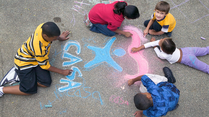 Children coloring and drawing the CASA logo with sidewalk chalk.