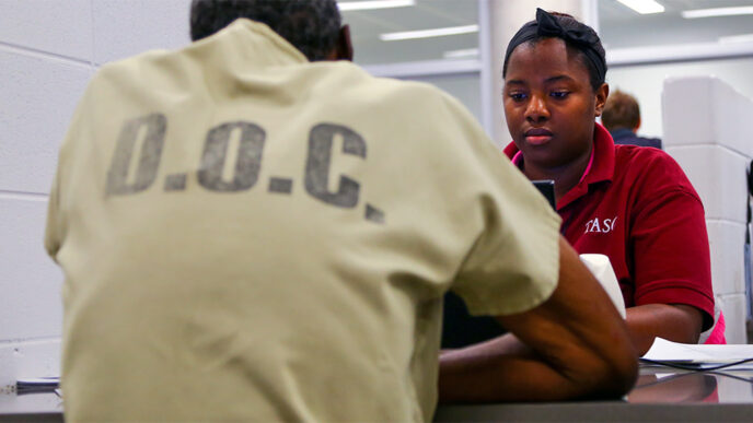 A staff member from TASC visits with an inmate.