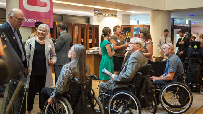 A group of people talking in the lobby of the Goodman Theatre|A group of people talking in the lobby of the Goodman Theatre.