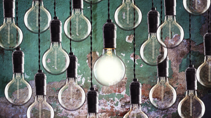 A series of light bulbs hanging against a colorfully painted wall.
