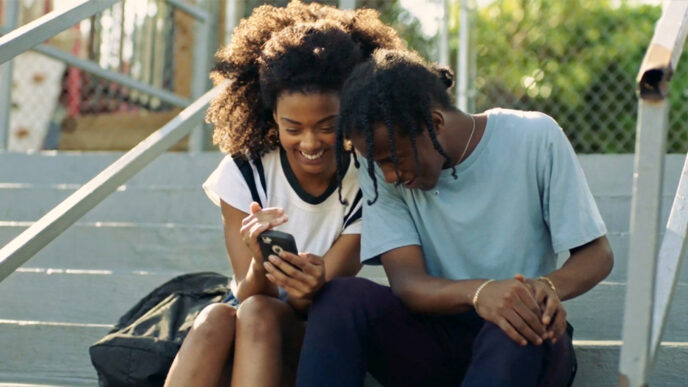 Two teenagers sitting on steps outside.