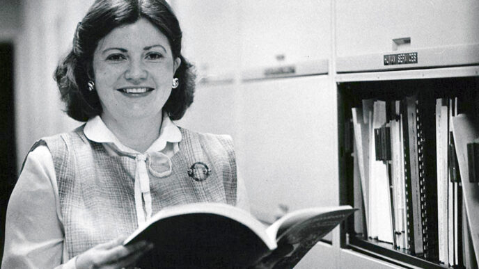 Barbara Long holds a book in the Trust archives|Cover of the Declaration of Trust document.