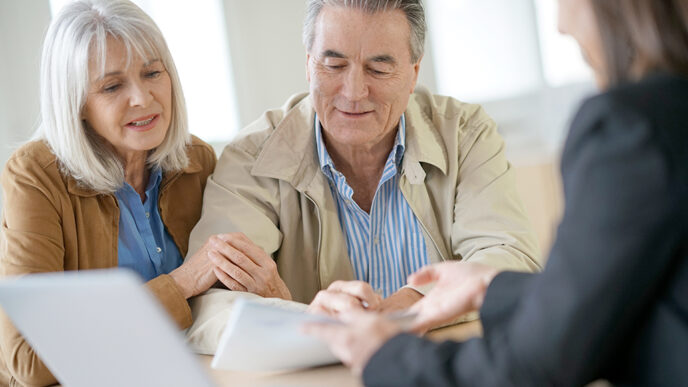 Baby boomer couple talks with a financial advisor.