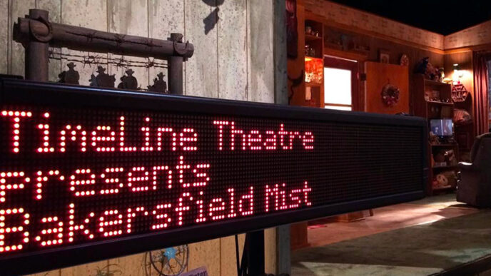 A captioning screen beside a theater stagereads TimeLine Theatre presents Bakersfield Mist.