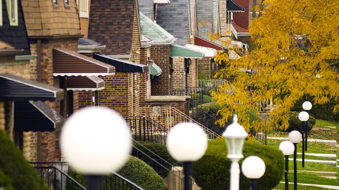 Street lamps in front of a row of single-family homes|Line chart titled Average Percent Over/Under Assessment by Percent White.