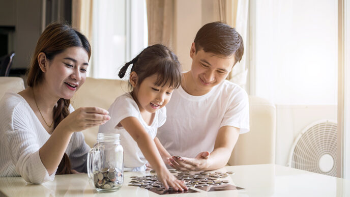 A little girl site with her parents in a living room.