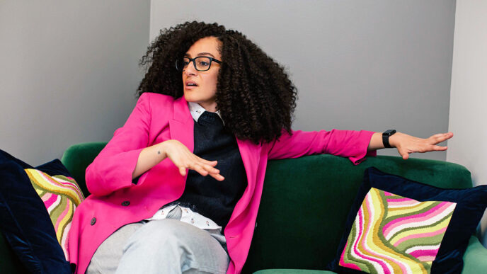 A woman wearing glasses seated on a couch.