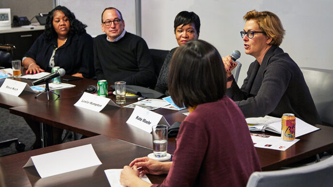 A group of panelists seated at a long conference table|A group of panelists seated at a long conference table|A group of panelists seated at a long conference table|A panelist speaks into a microphone|A group of panelists seated at a long conference table||Map of the Chicago region showing rates of food insecurity||.