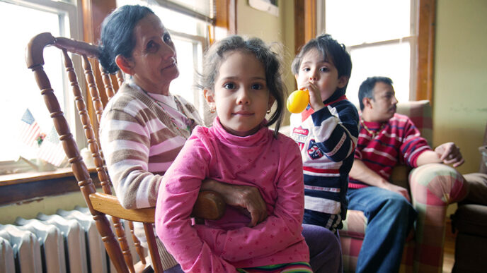 A family of four sit in a living room.