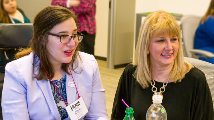 Two women sit at a table.