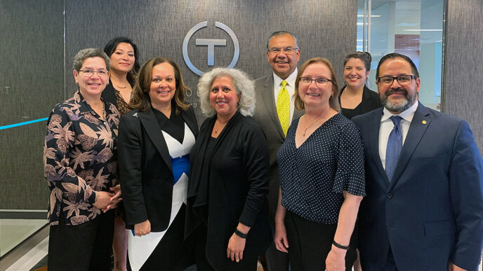 A group of people stand in an office lobby.