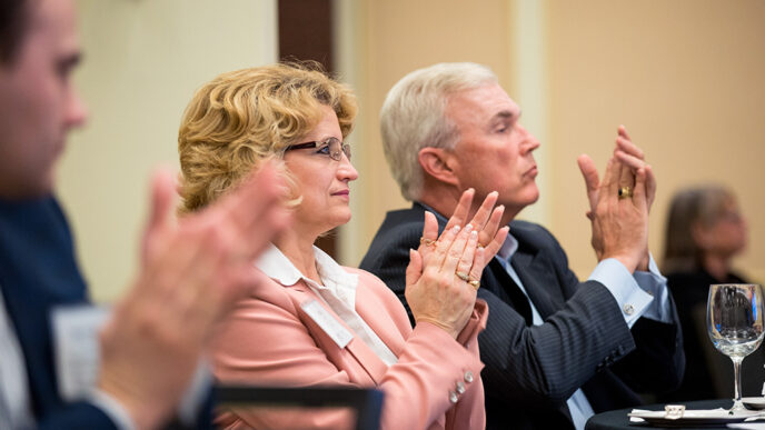 A group of people seated in a meeting room.