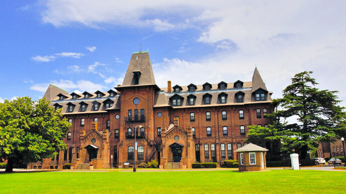 A large red brick building with a large lawn in front|Nate Sutton|Mallory Sutton.