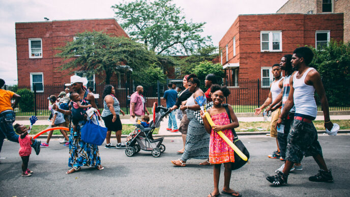 People walk past a brick residential building